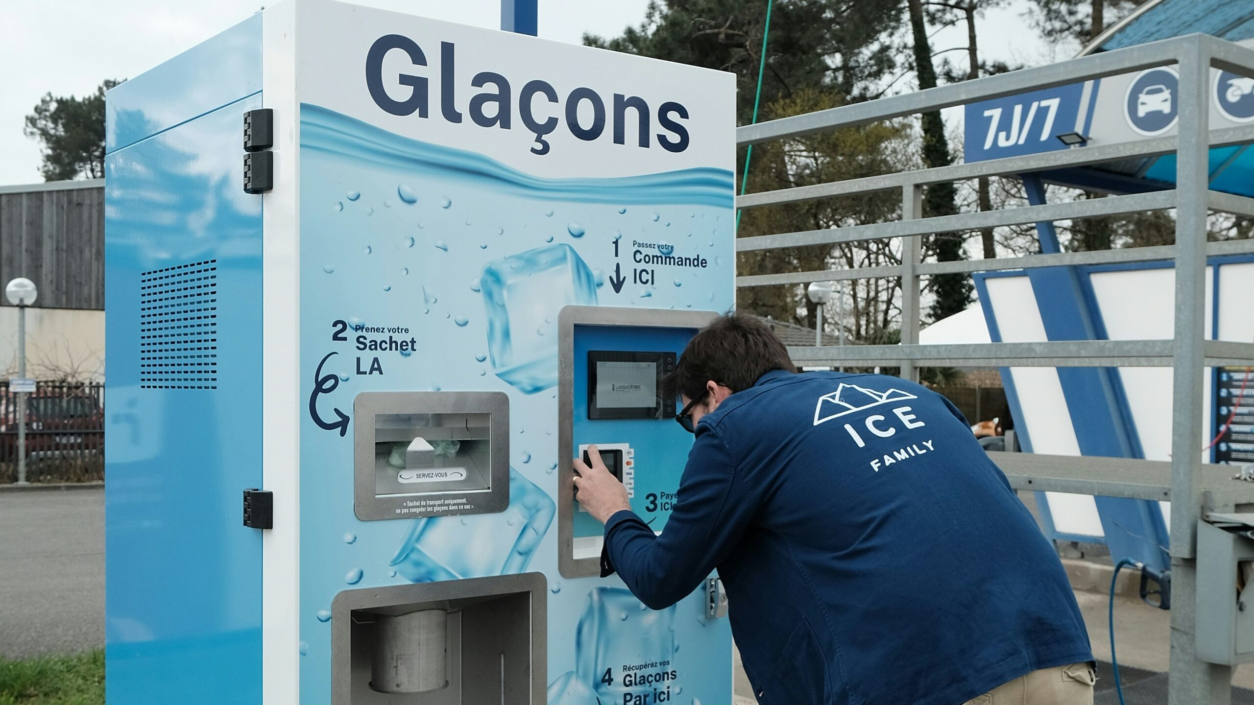 A man is operating an ice vending machine.