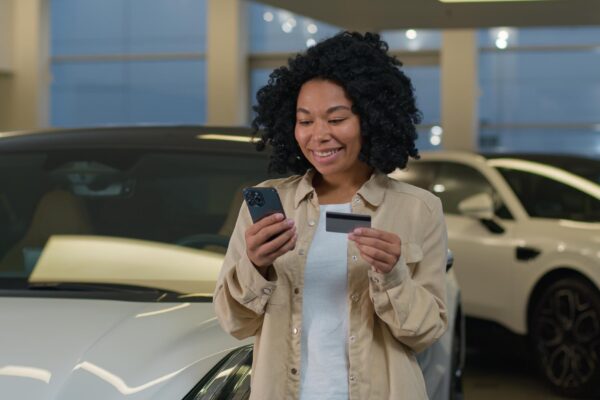 African american happy customer woman buyer hold credit card mobile phone shopping buying new luxury