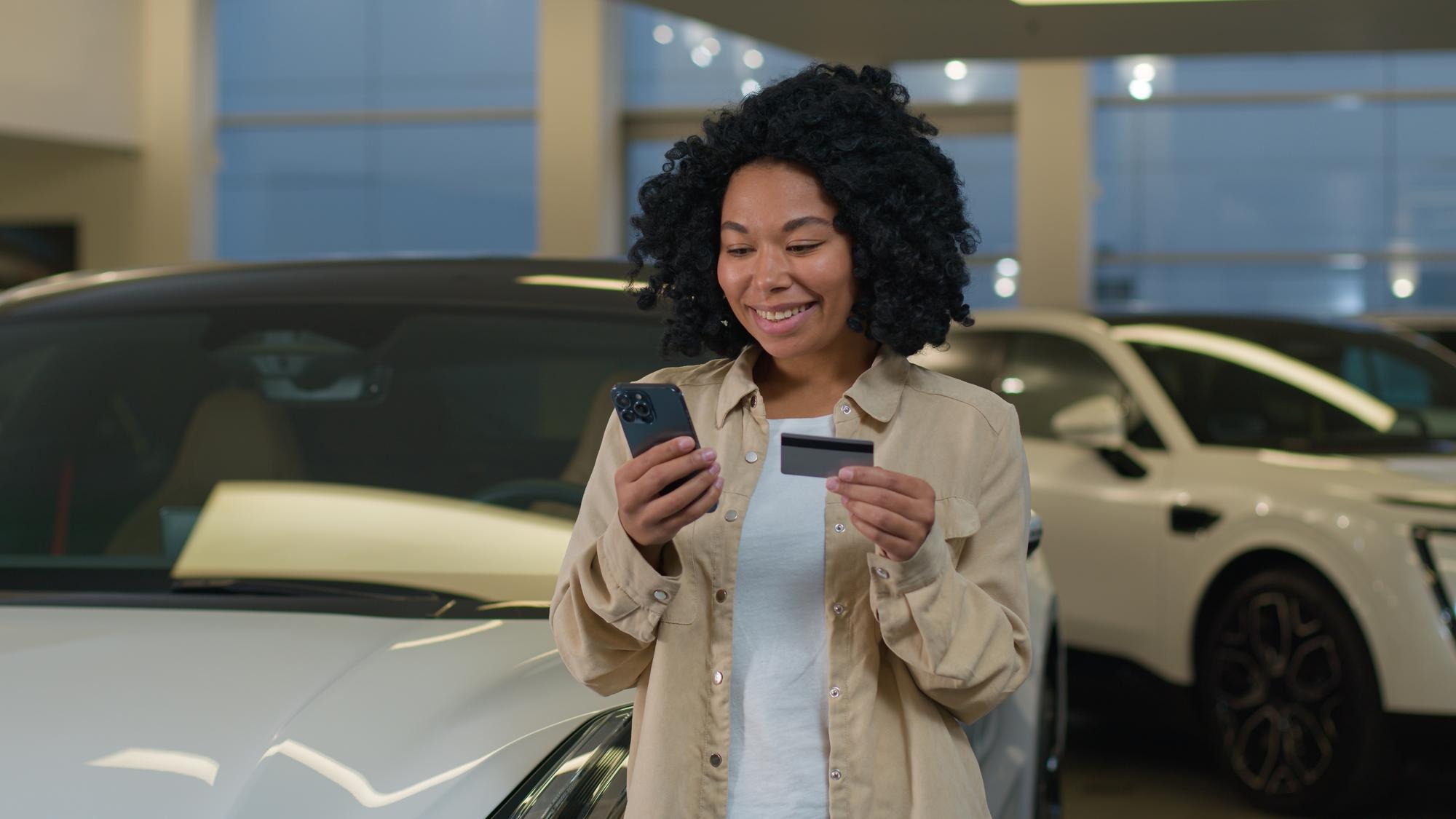 African american happy customer woman buyer hold credit card mobile phone shopping buying new luxury