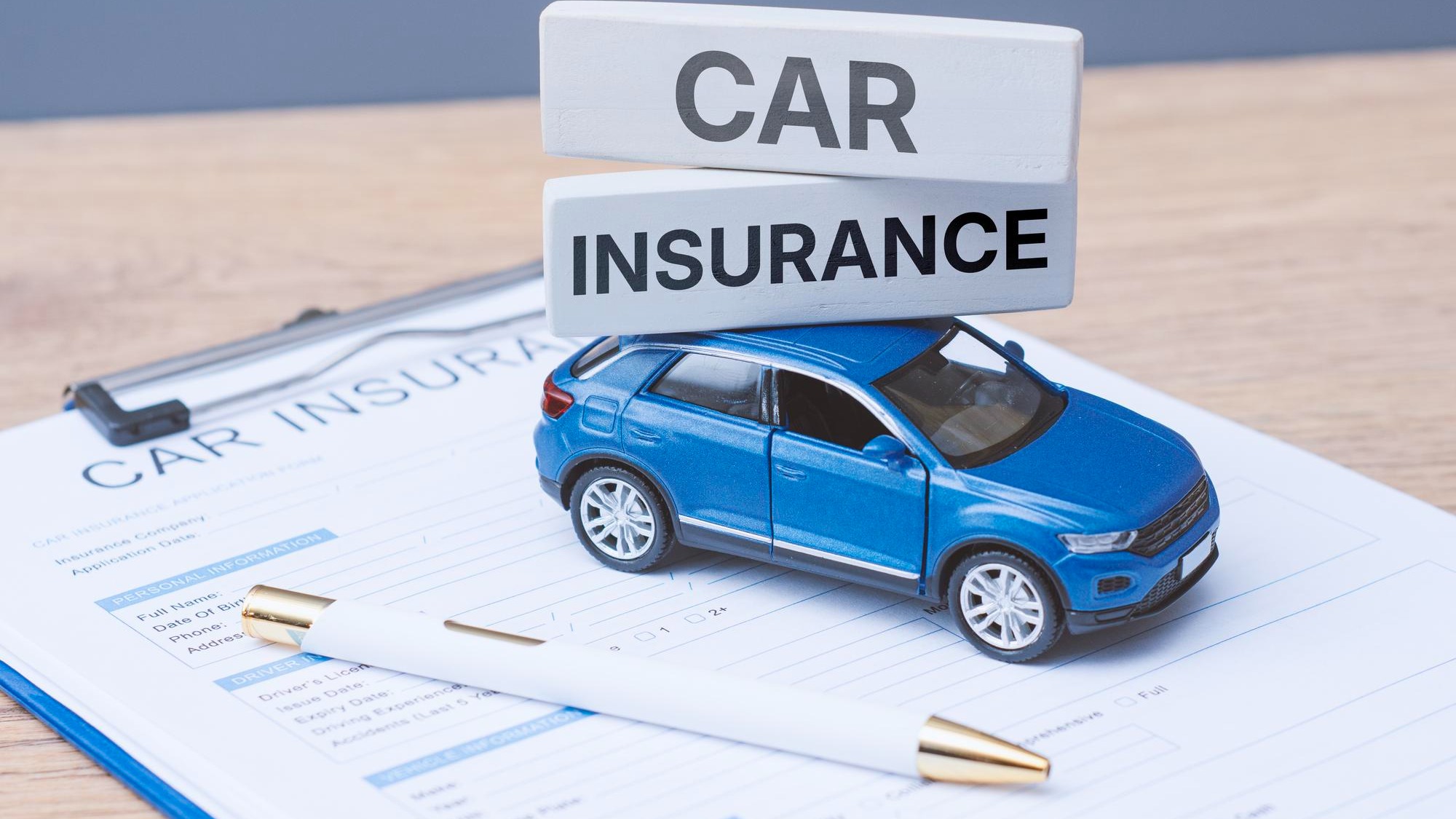 Toy car insurance text blocks on a insurance application form and clipboard Auto protection vehicle