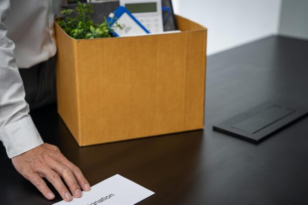 Business man sending resignation letter and packing Stuff Resign Depress or carrying business cardboard box by desk in office Change of job or fired from company