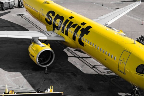 A yellow spirit airlines airplane at the gate.