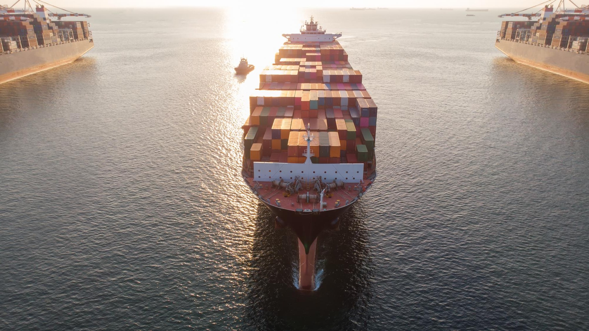 Aerial in front of cargo ship carrying container and running xAnear international custom sea port for export cargo