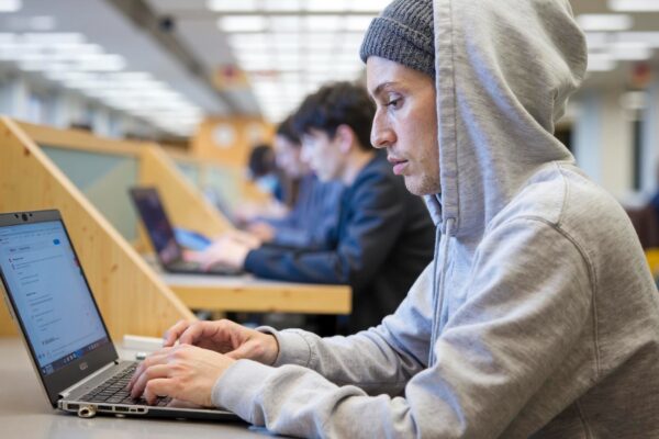 Focused student working on laptop in university library