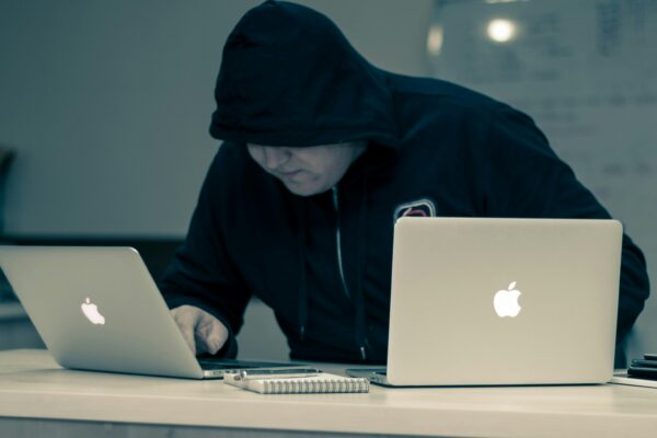 man in black hoodie using macbook
