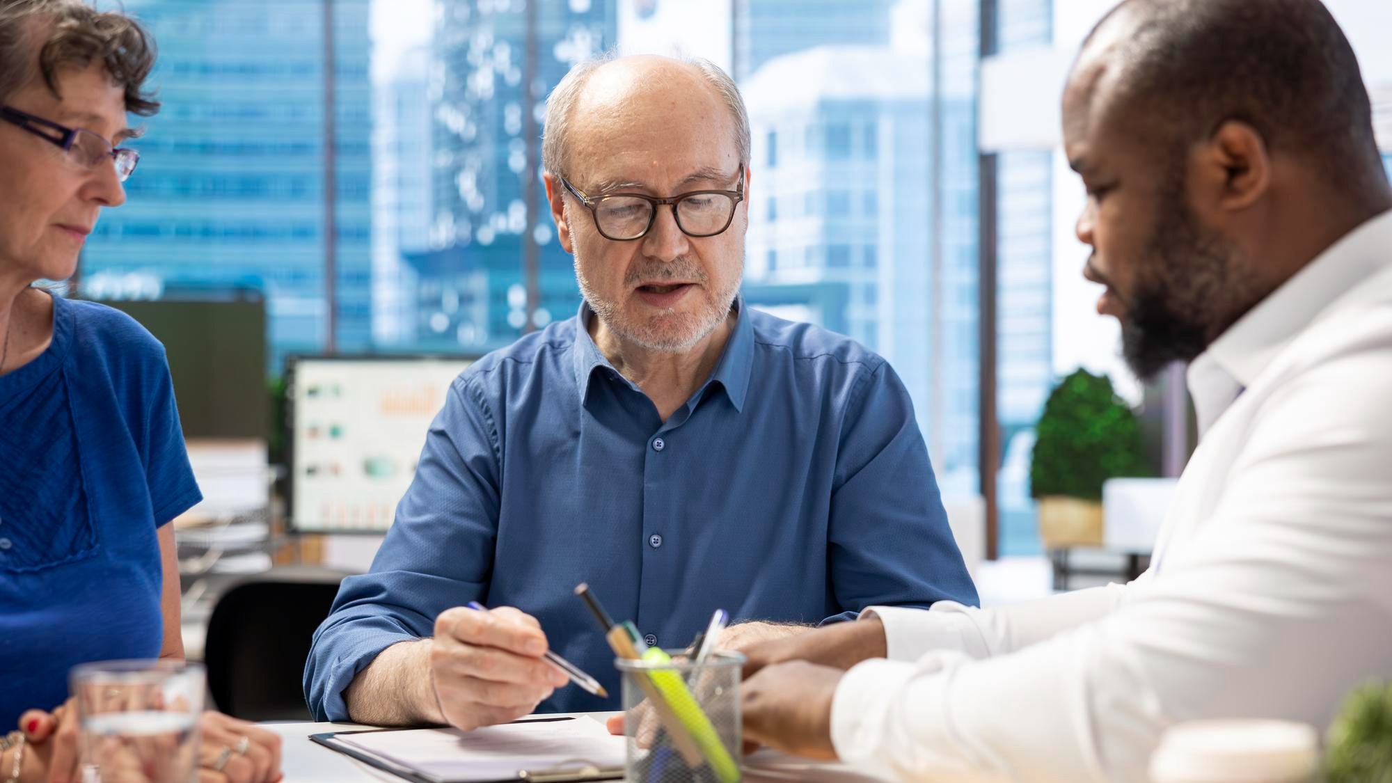 Mature person signing a contract with insurance agency banker