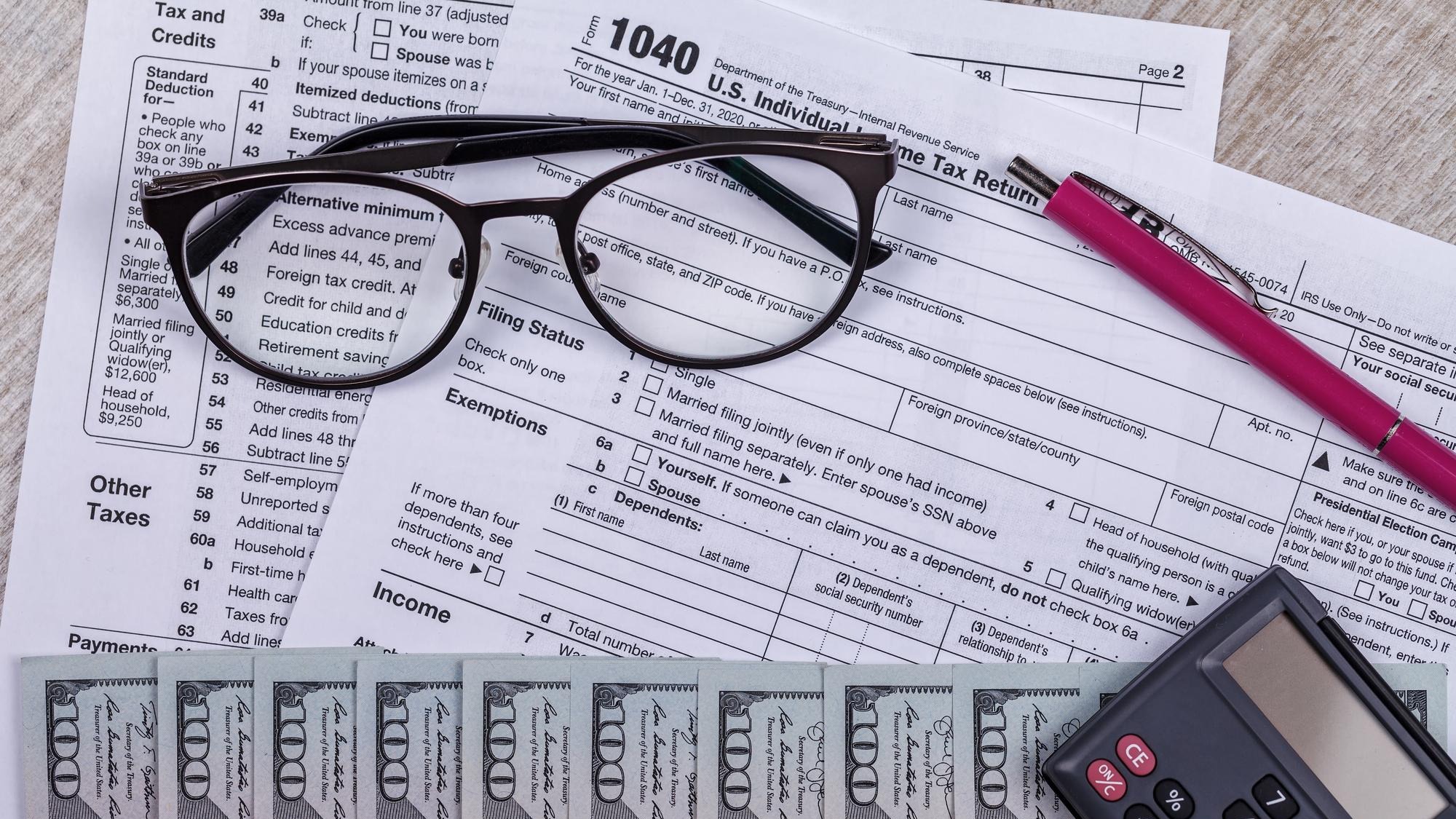 Income tax with instruction money calculator and glasses tax payment and filing concept