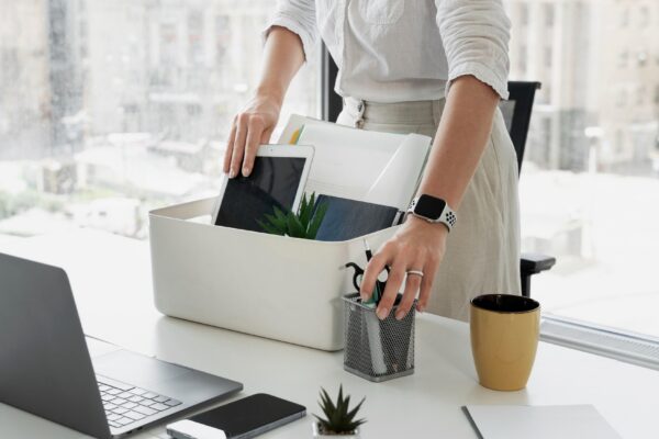 Side view woman packing desk items