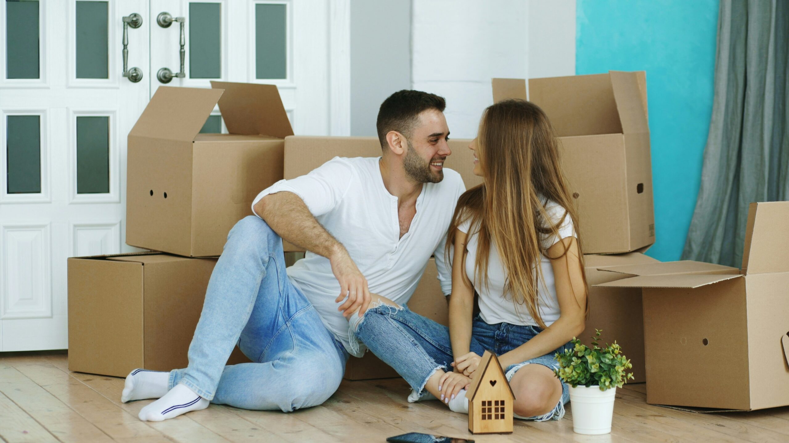 Couple surrounded by moving boxes in new home
