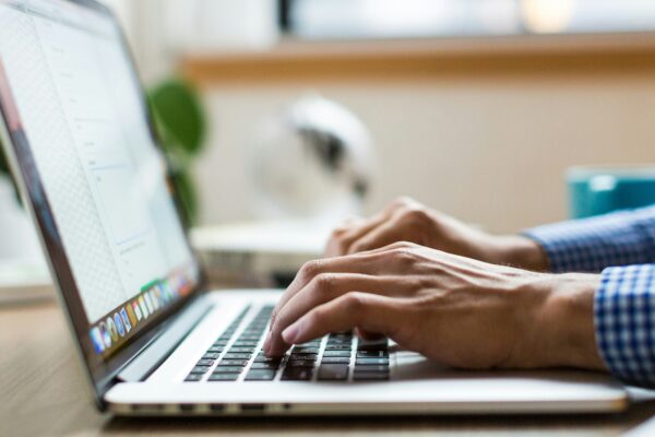 person typing on silver MacBook