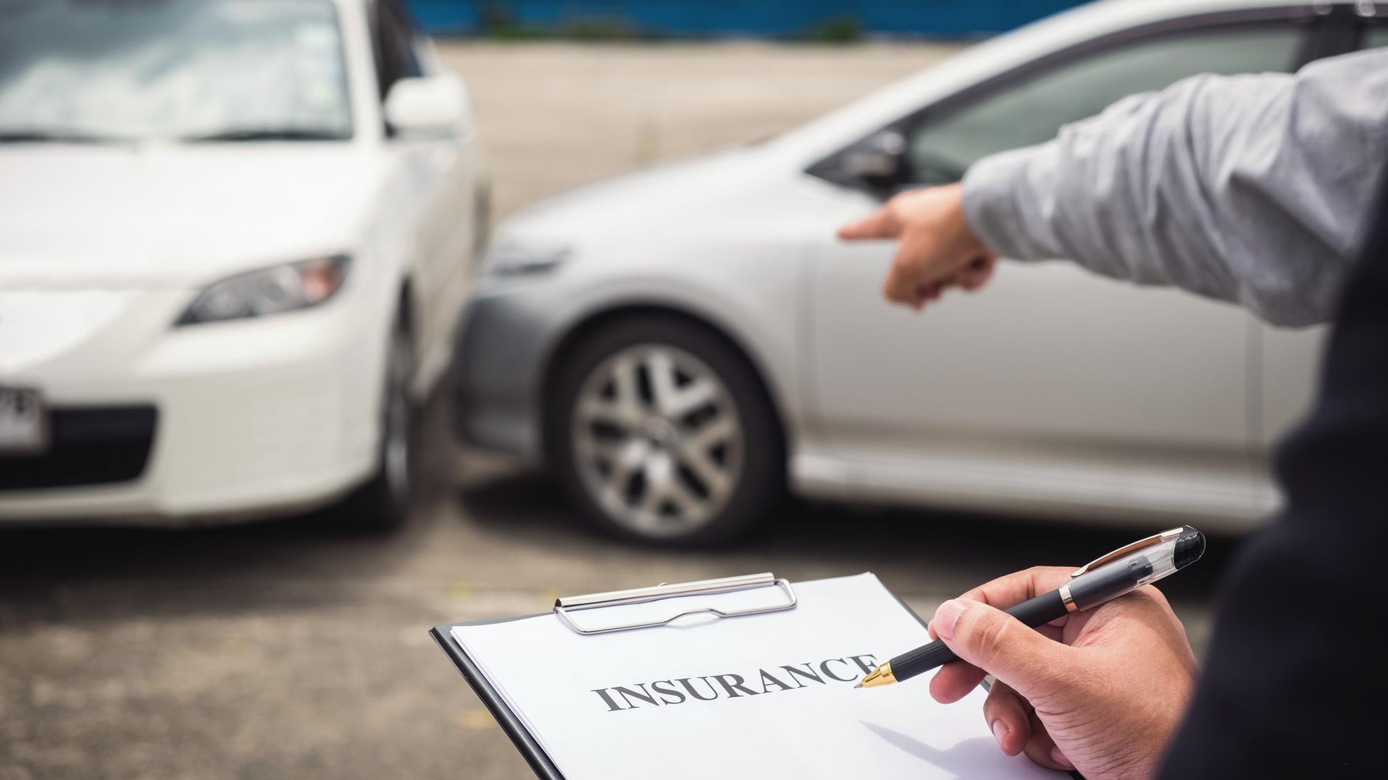 Cropped hand of insurance agent by customer gesturing at car