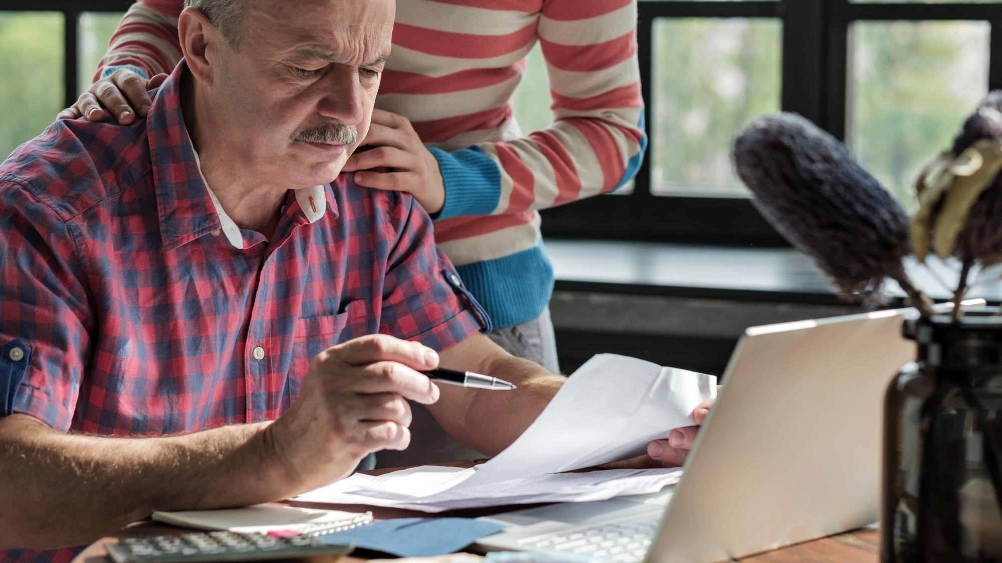 Serious mature hispanic man man checking home finance calculating money