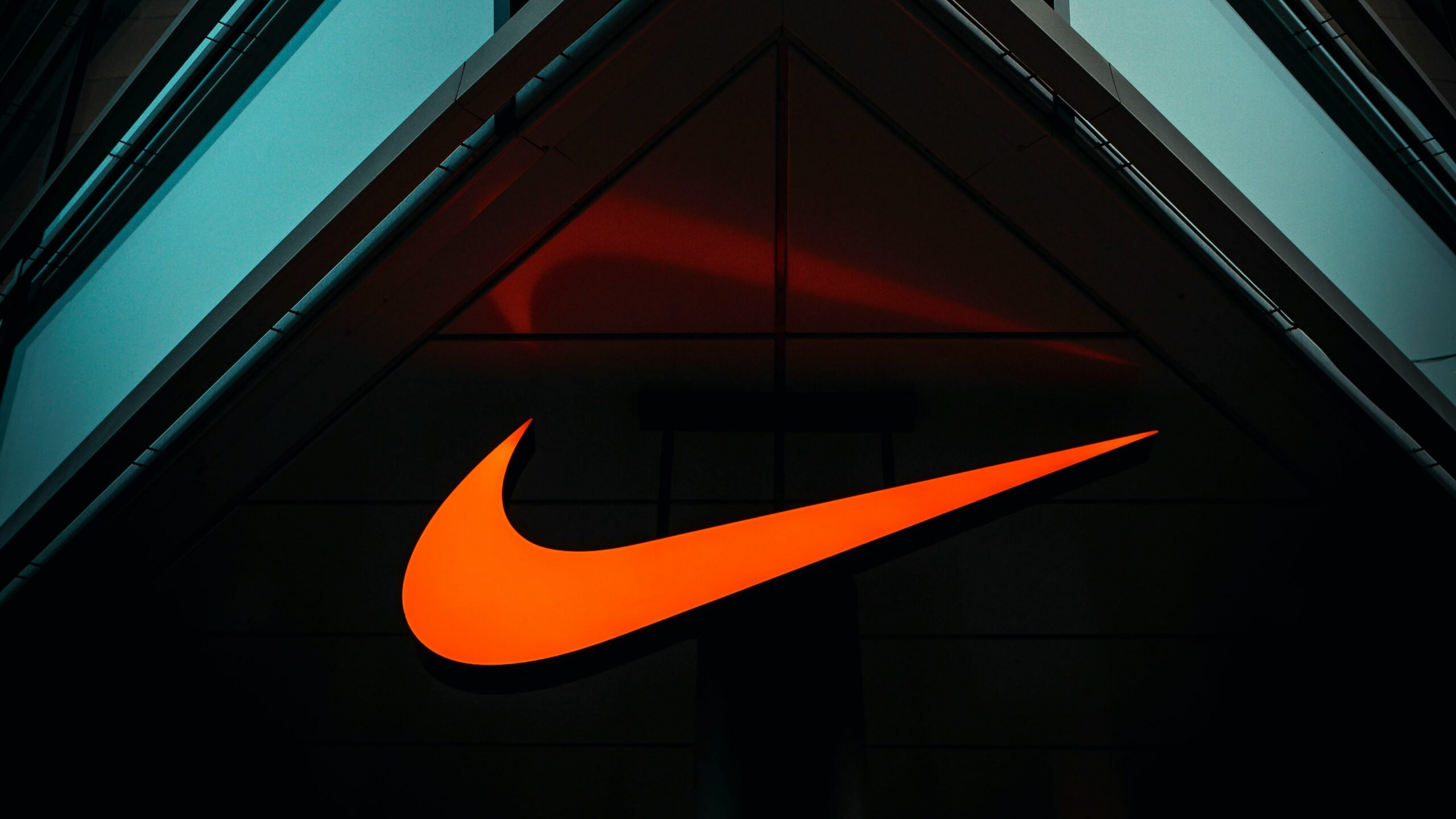 the nike logo is lit up on the side of a building