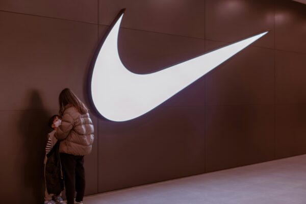 a woman standing in front of a nike logo