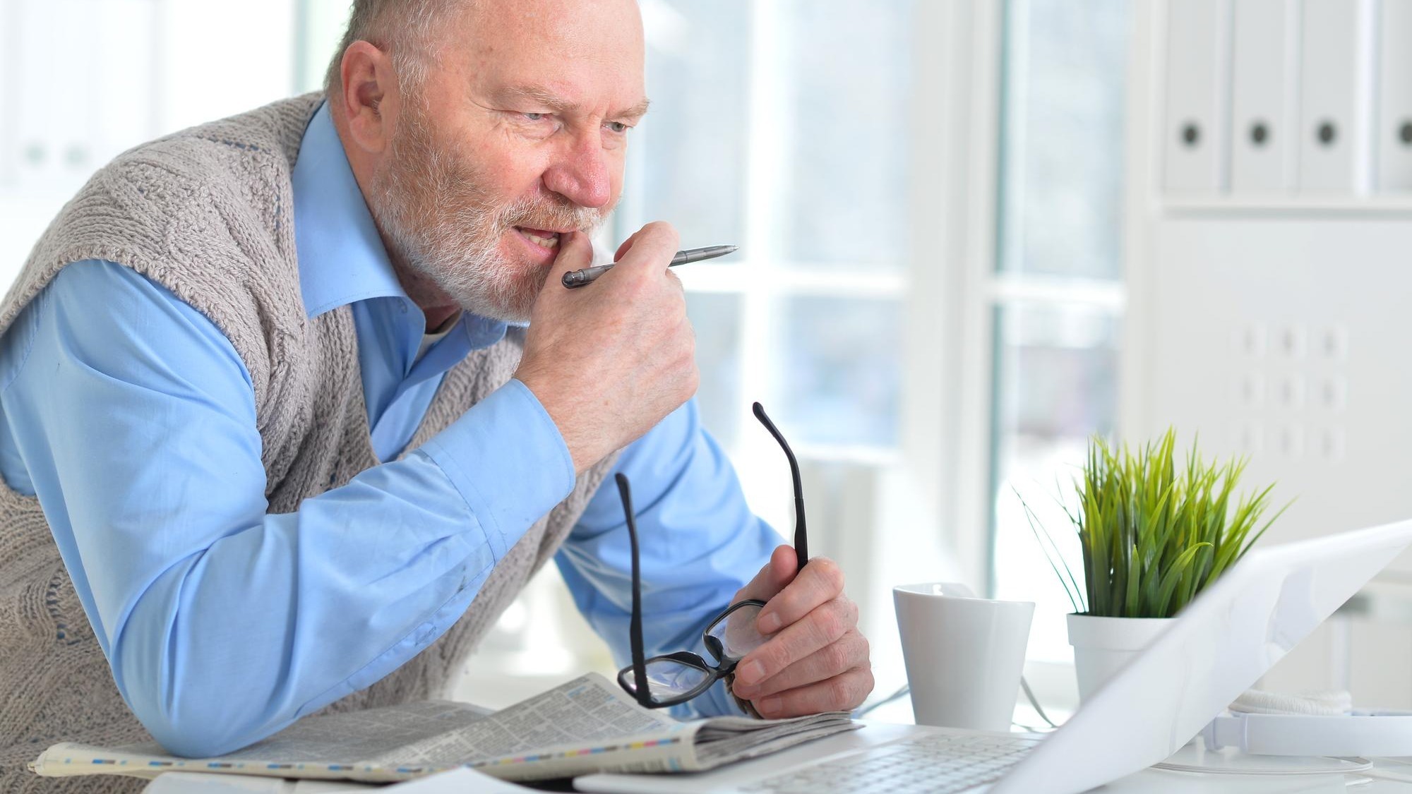 Portrait of an elderly man using a laptop in an office