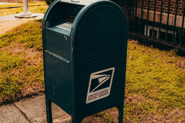 a mailbox on a sidewalk in front of a house