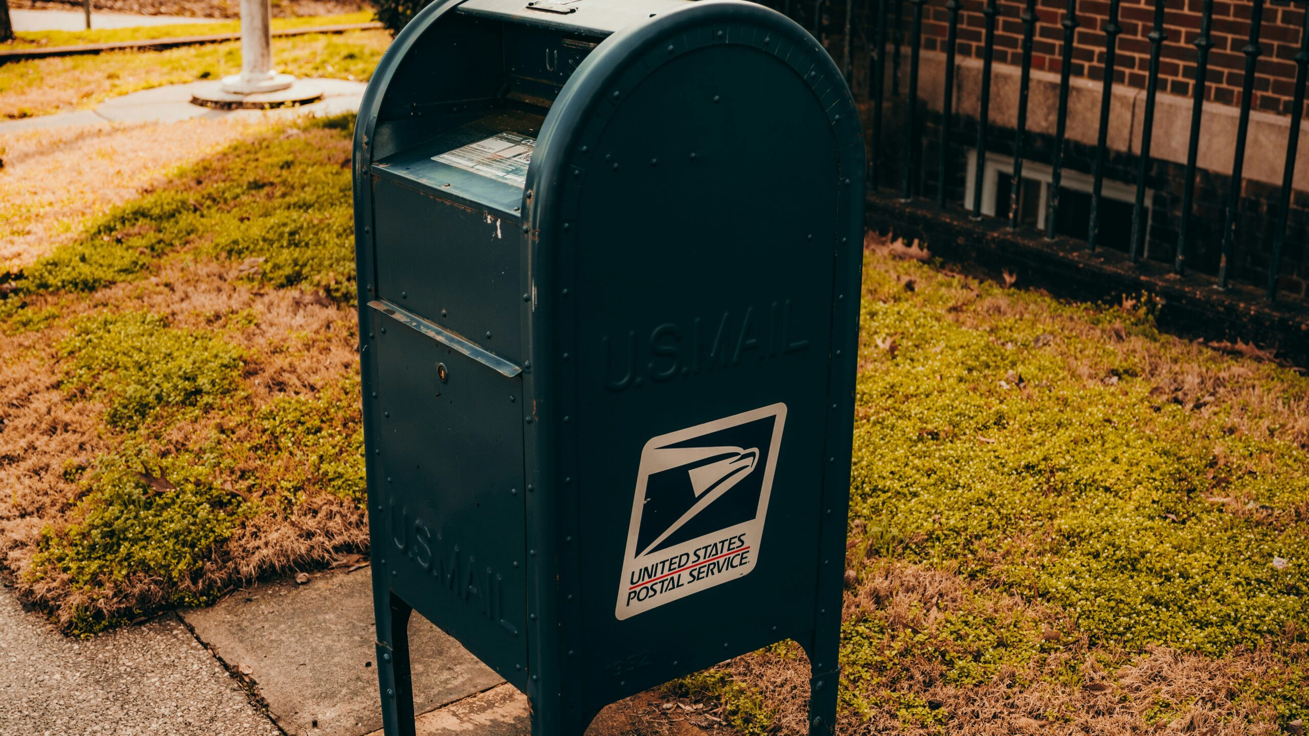 a mailbox on a sidewalk in front of a house