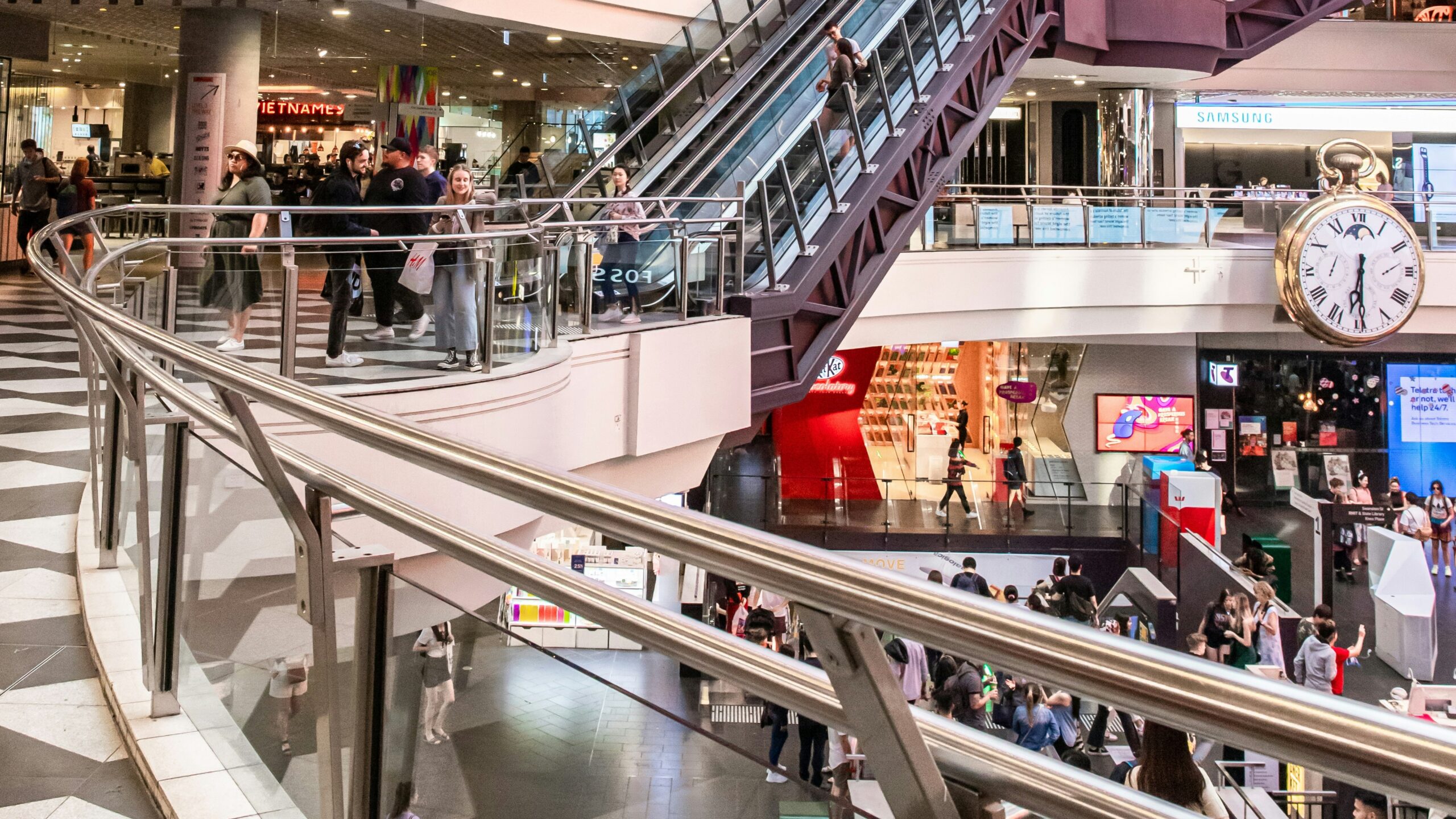people walking inside building with escalator