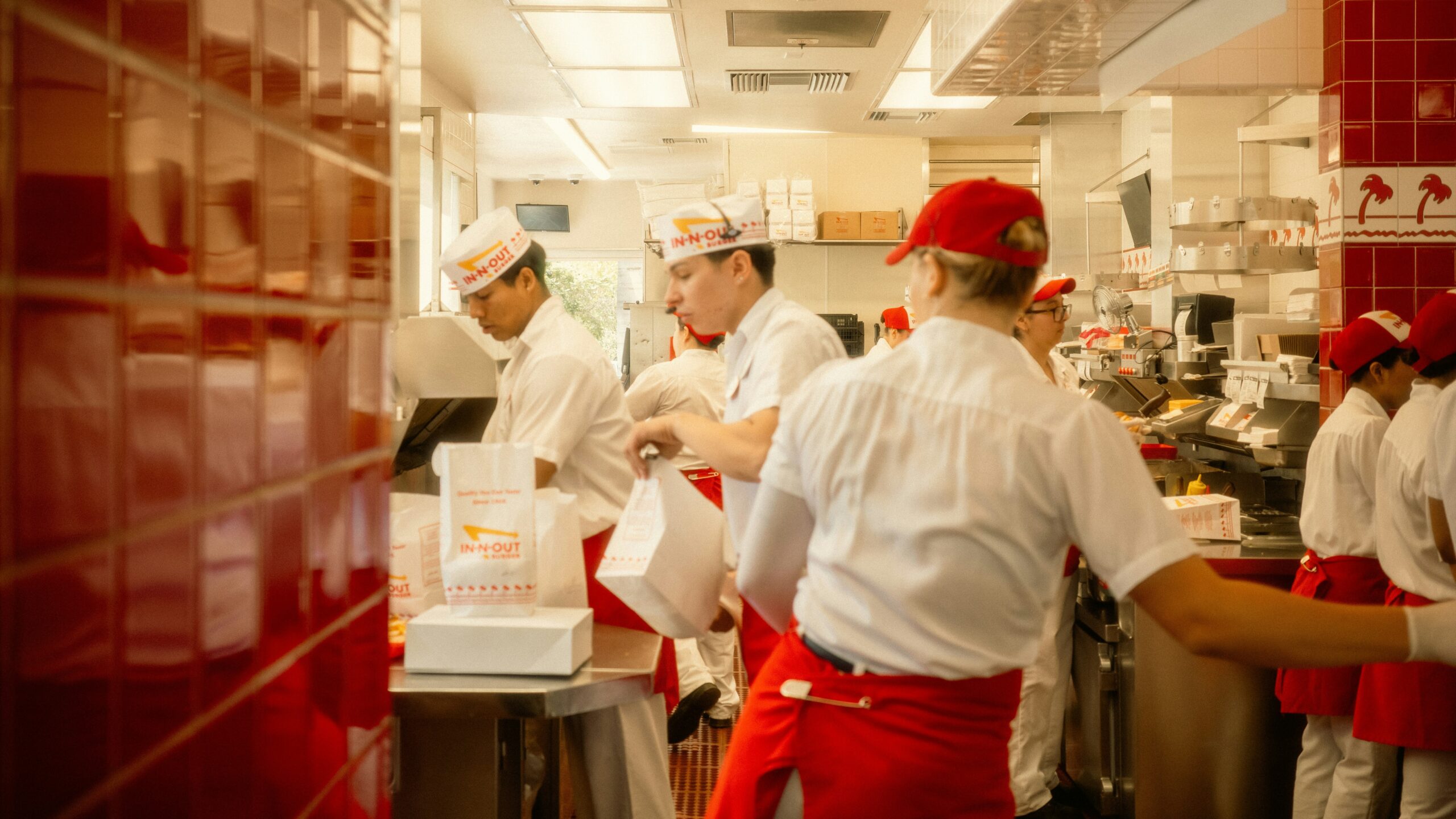 Restaurant workers preparing food in a busy kitchen.