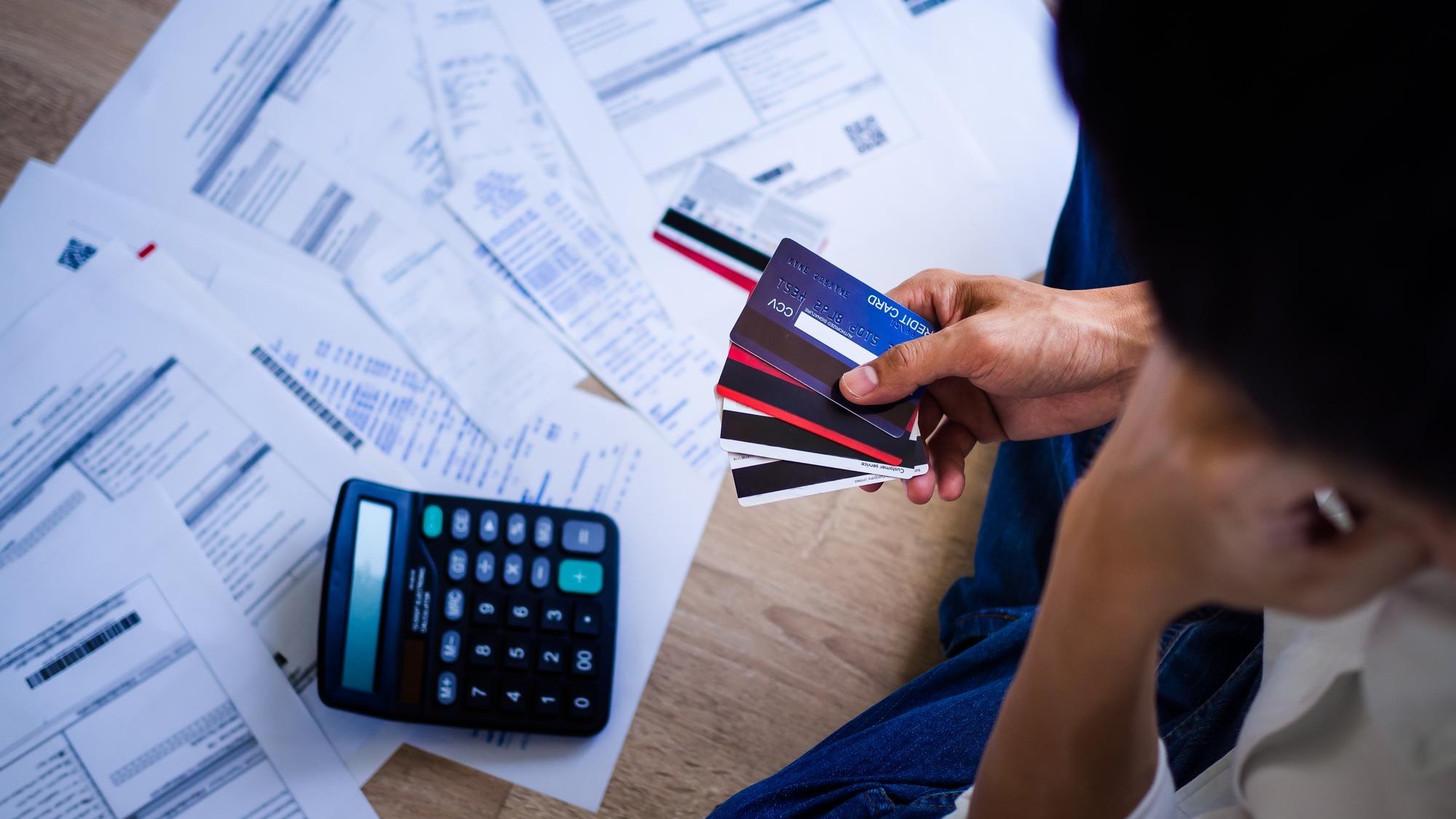 Business people are stressed about credit card debt and many bills on the floor