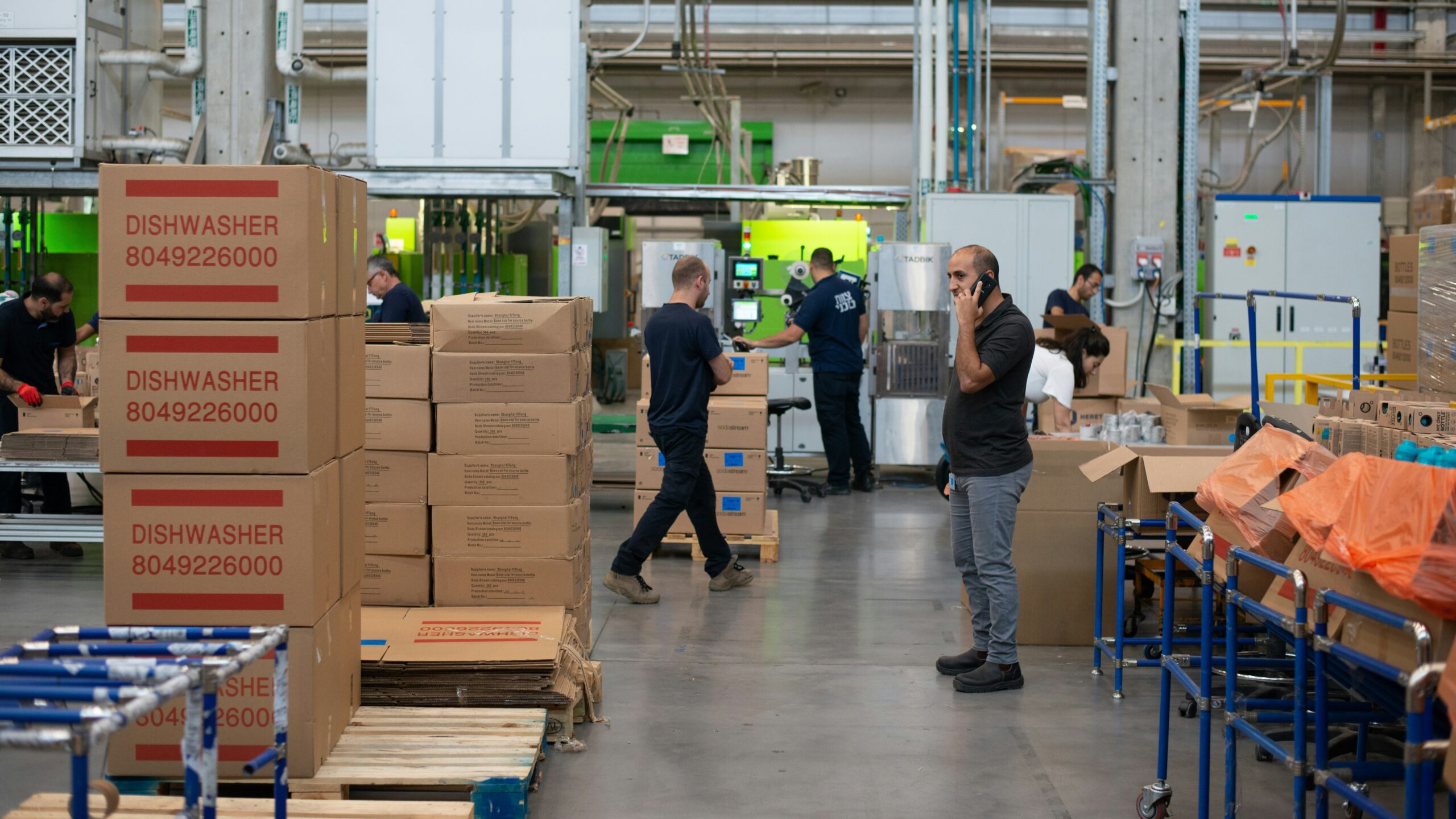 man in gray shirt standing beside brown cardboard boxes