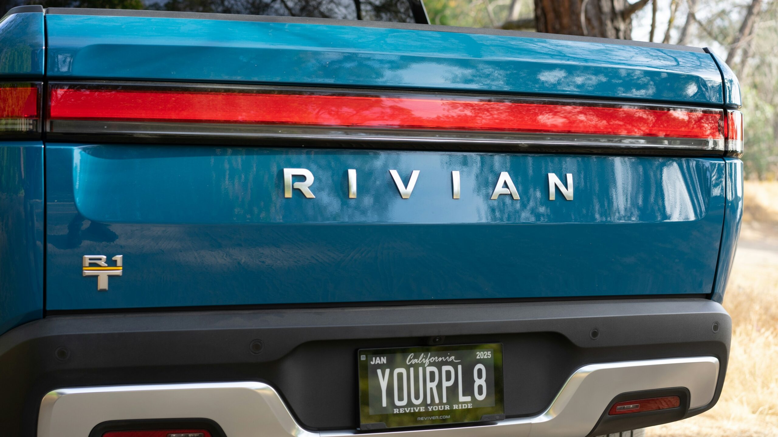 the back end of a blue car with a license plate