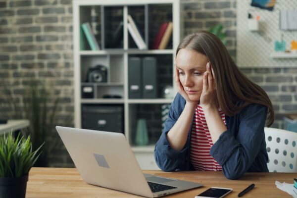 a woman sitting at a table with a laptop in front of her