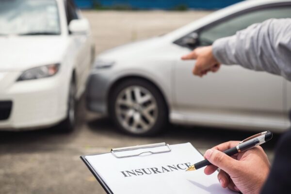 Cropped hand of insurance agent by customer gesturing at car