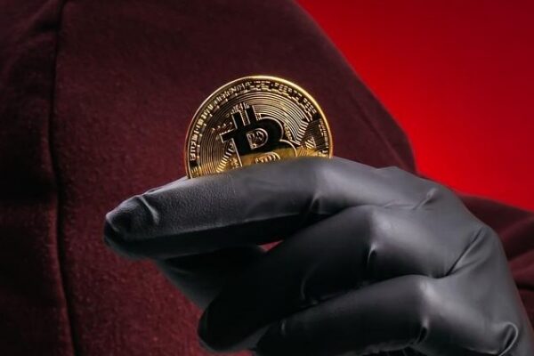 Crypto scam concept showing anonymous hacker stealing Bitcoin through phishing and fake investment schemes Cybercriminal targeting digital assets with fraud impersonation and high return promises
