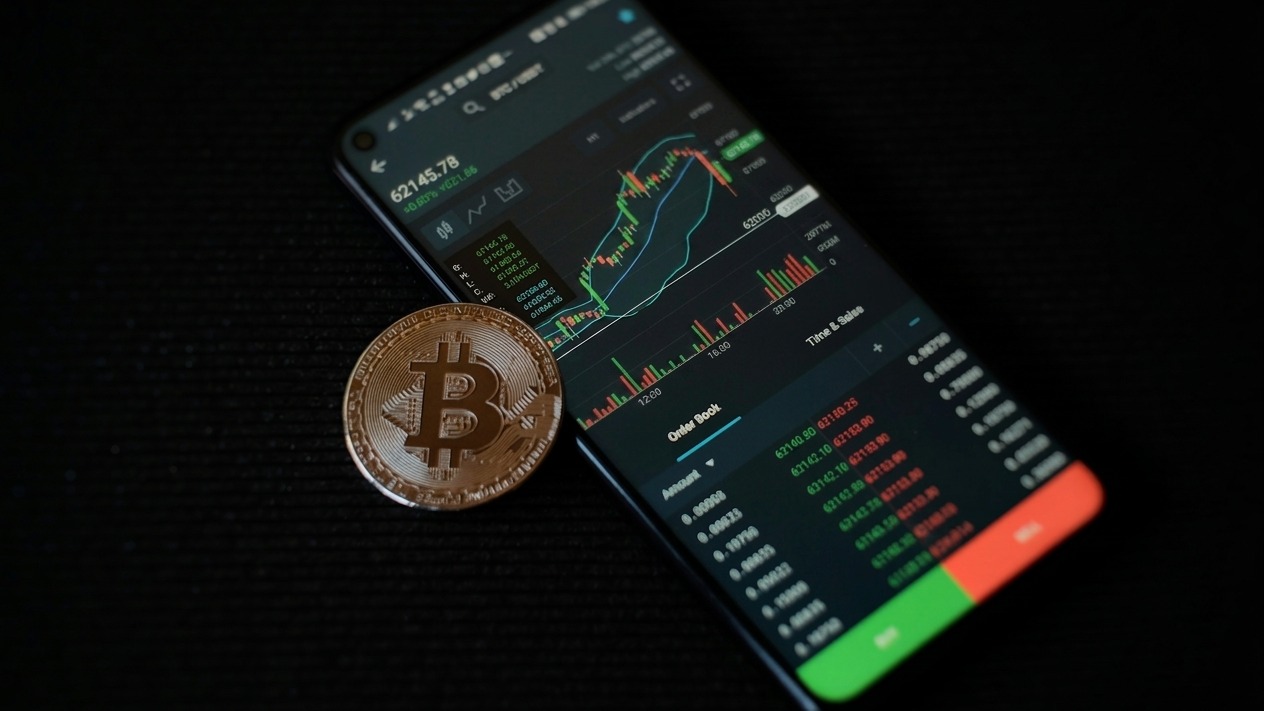 a bitcoin sitting on top of a smart phone