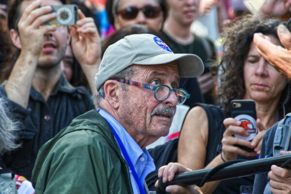 man wearing cap at middle of people