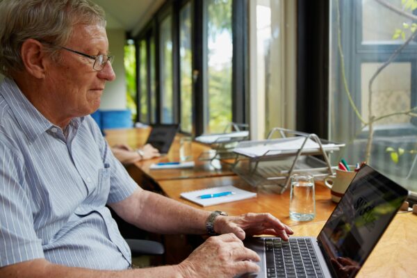a man sitting at a table using a laptop computer