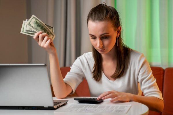 A young woman who is in a state of stress calculates monthly housing costs and installments for a ca