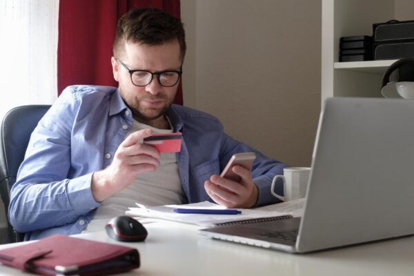 Man shopping online with credit card and computer during quarantine