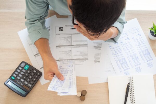 The butler worried hands touch forehead which has many expenses such as electricity bills, internet bills, mobile phone bills and credit card bills on hand, no money to pay. debts concept