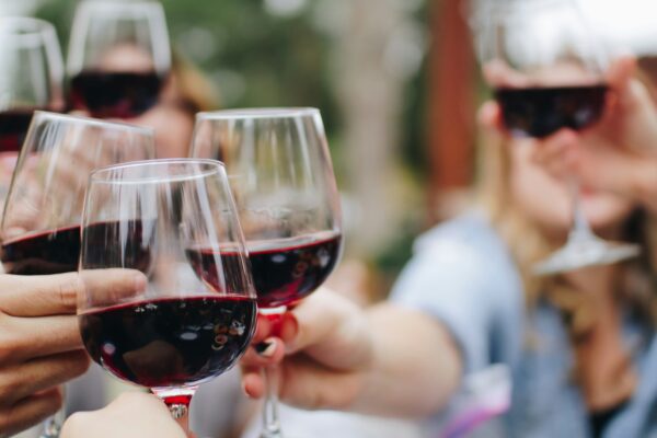 people tossing their clear wine glasses