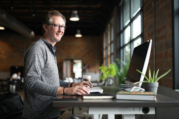 a man sitting at a desk with a laptop