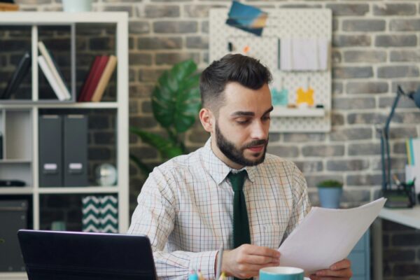 a man sitting at a desk in front of a laptop