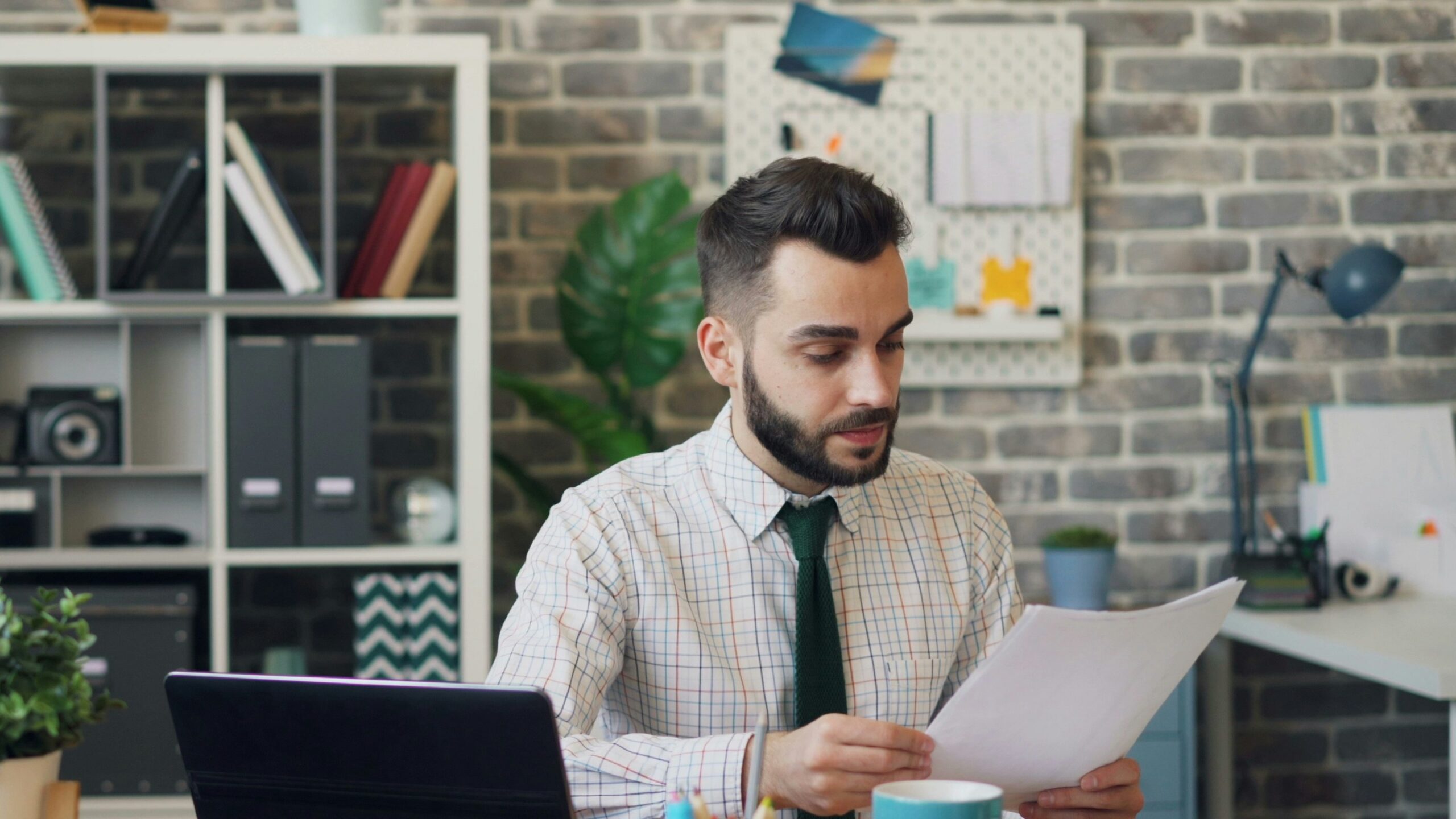 a man sitting at a desk in front of a laptop