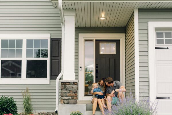 a couple of people that are sitting in front of a house