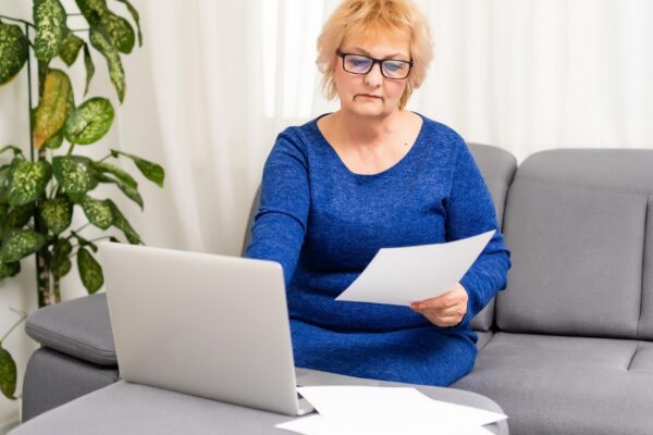 Image Credit: Happy mature older woman video calling on laptop working