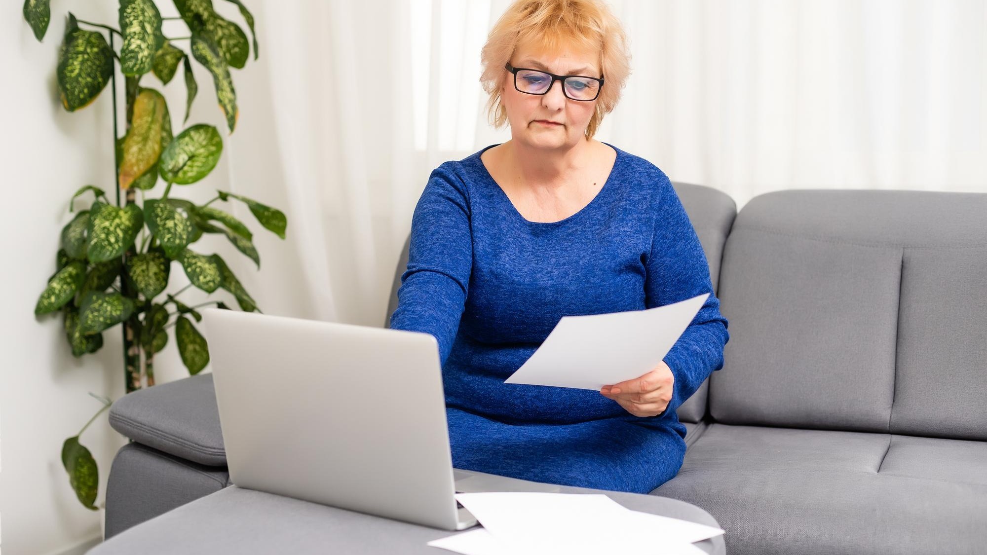 Image Credit: Happy mature older woman video calling on laptop working