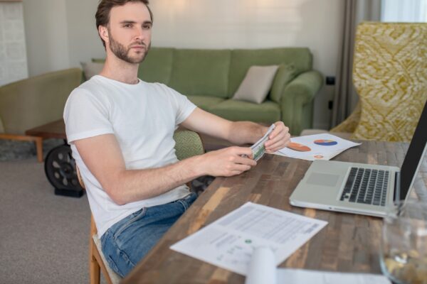 Young bearded man working on a laptop and looking concentrated