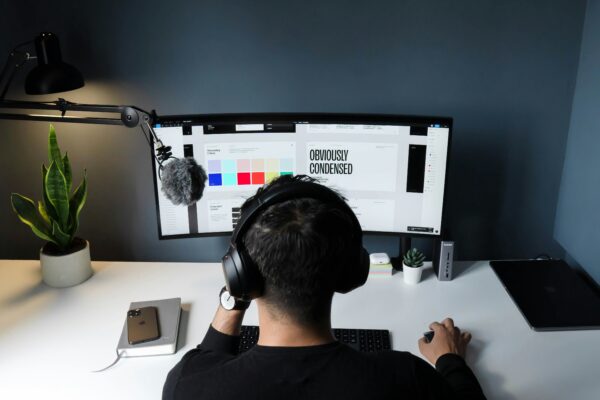 man in black shirt sitting in front of computer