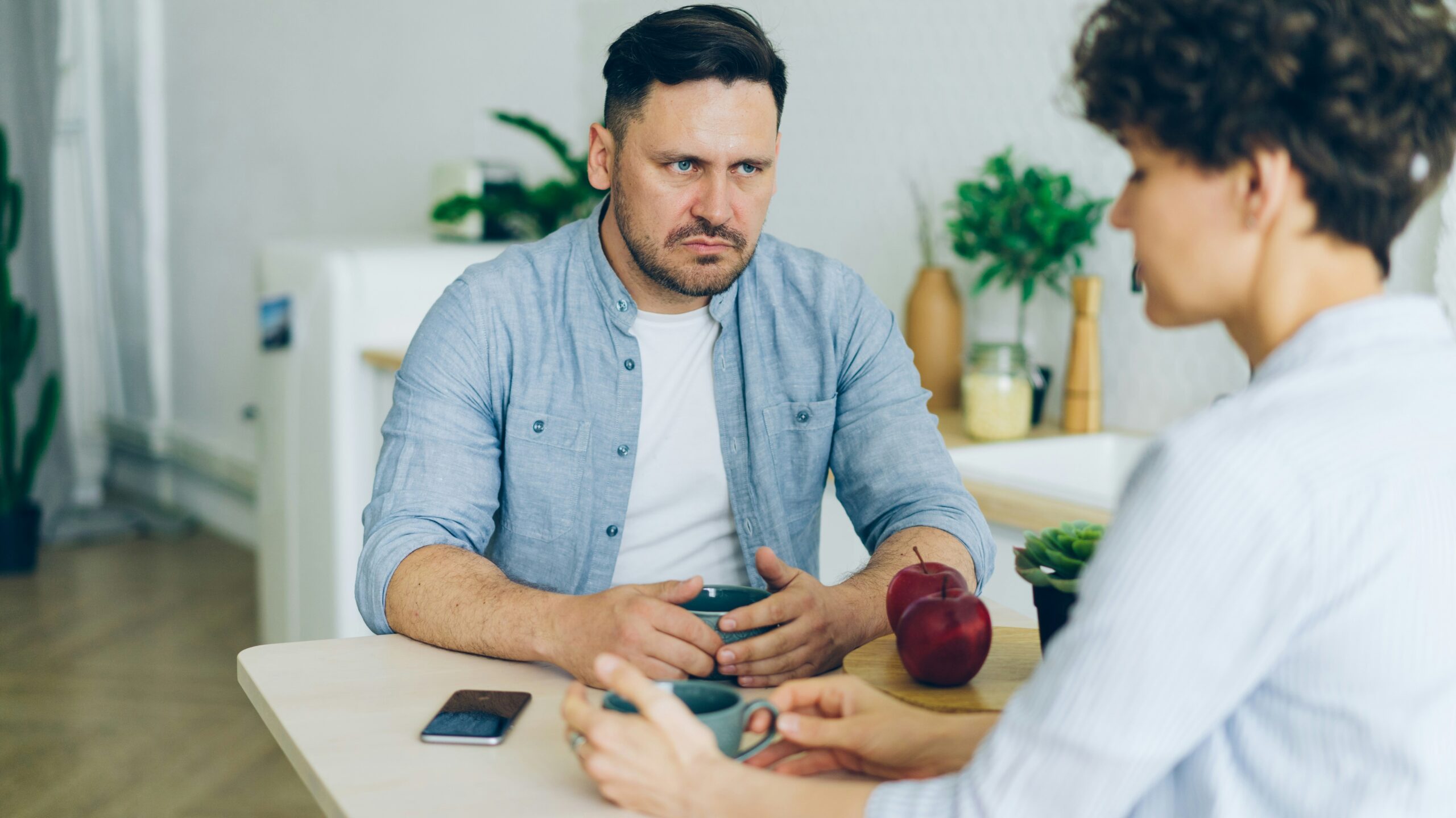 a man sitting at a table talking to a woman