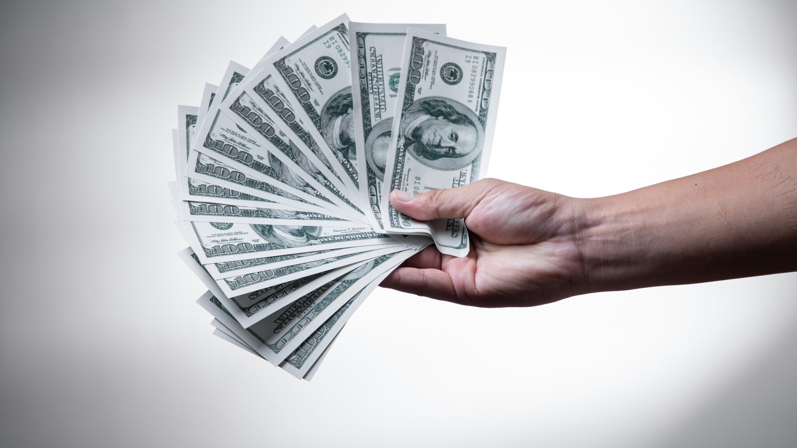 person holding 100 US Dollar banknote