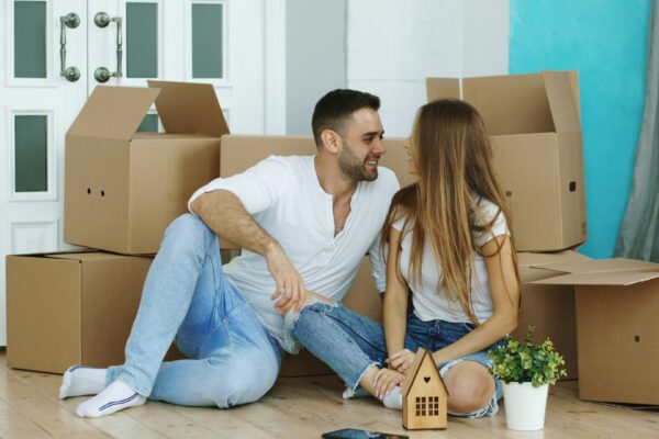 Couple surrounded by moving boxes in new home