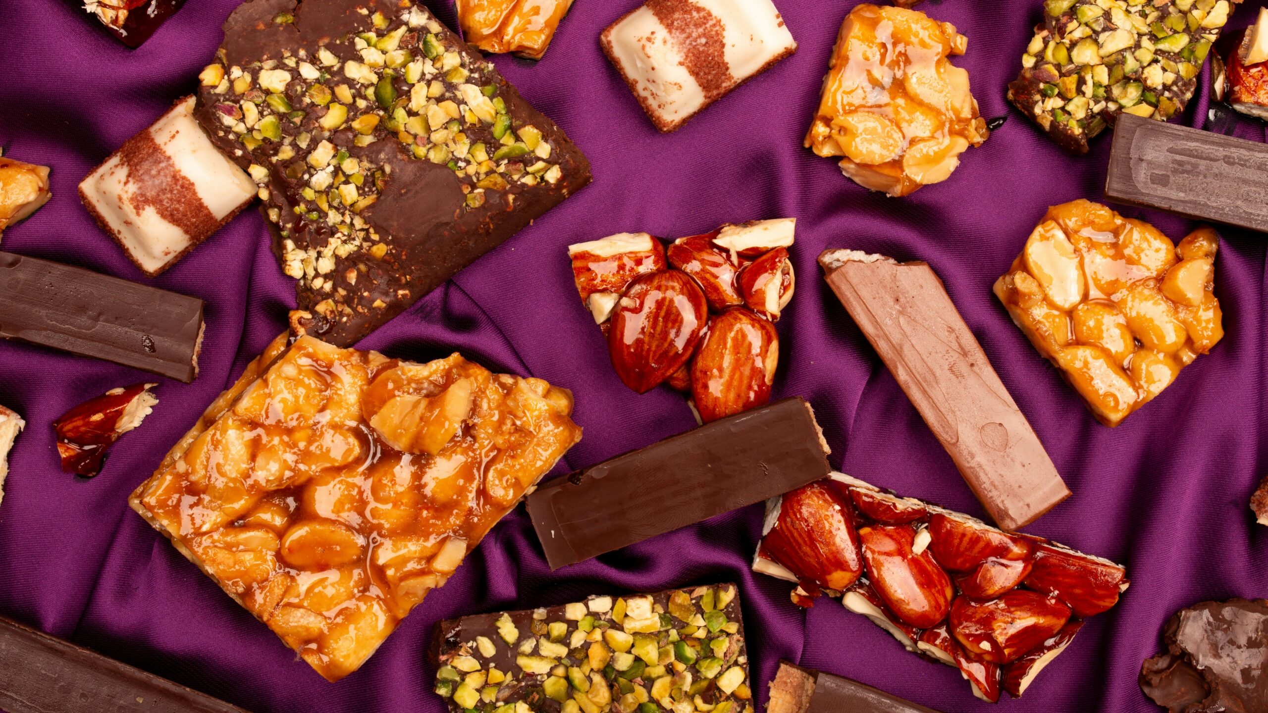 Assortment of chocolate bars and sweets on purple fabric