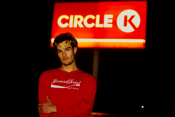 A man standing in front of a circle k sign