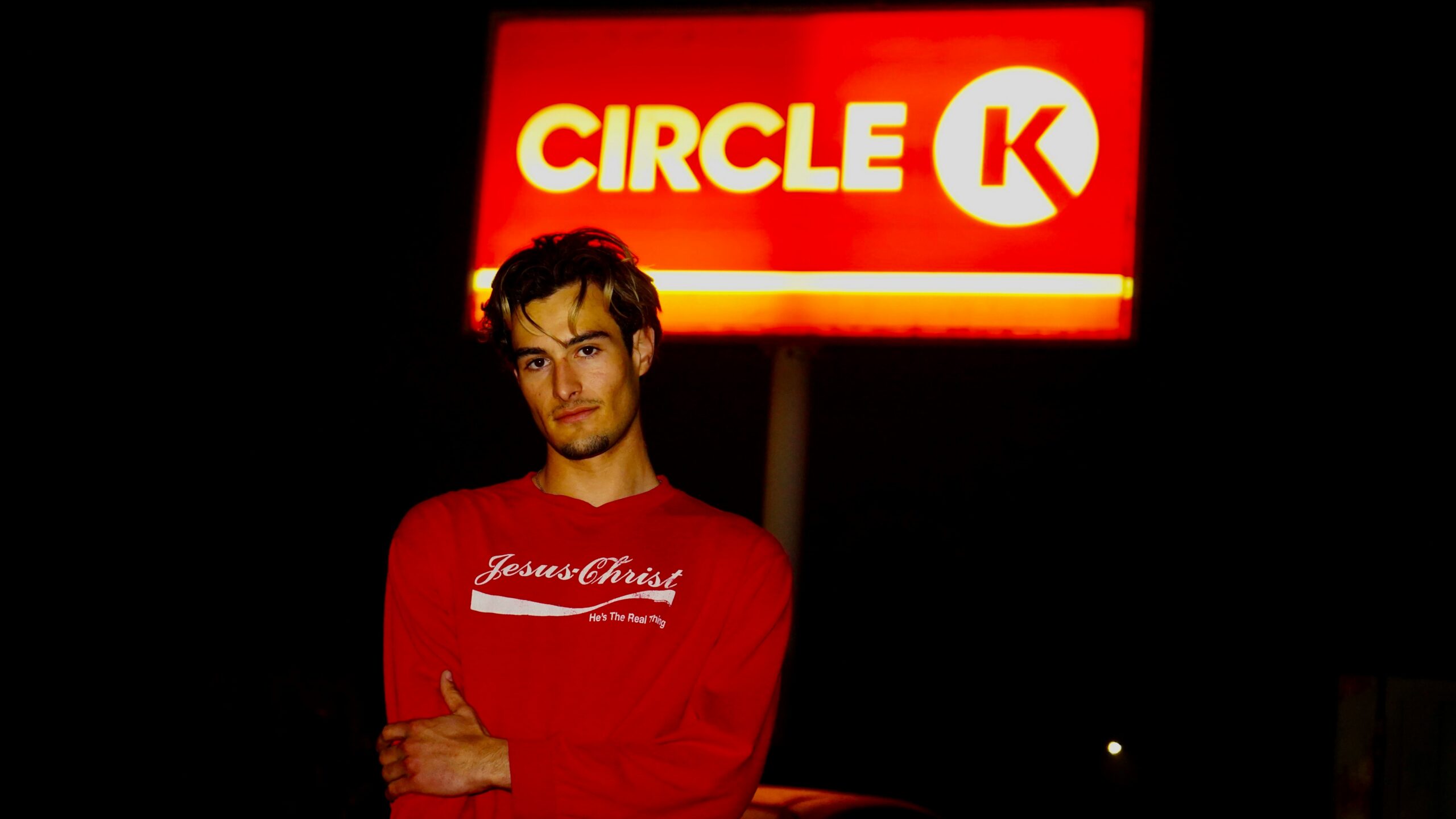 A man standing in front of a circle k sign